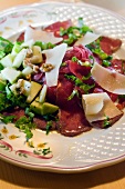 Close-up of carpaccio with cucumber and herbs on plate