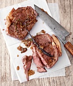 Roast beef with caramel and vanilla sauce on chopping board