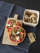 Unleavened bread pizzas with mushrooms, tomatoes and sheep's cheese