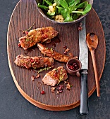 Lamb fillets in bread with cranberries on wooden board