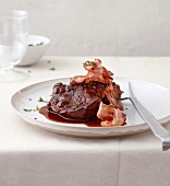 Beef with wine and pancetta on plate