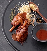 Lamb shank with honey almonds and couscous on plate