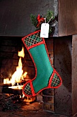 Green stockings made of felt hanging on fireplace