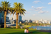 Couple sitting in park looking at cityscape in Perth Kings Park, Western, Australia