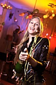Frau in Lederjacke feiert Silvester mit Champagner