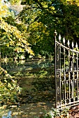 View of castle pond and trees through open gate