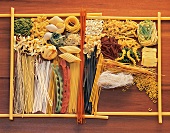 Different types of raw pastas on wood