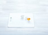 Egg yolk and egg shell on white chopping board