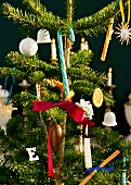 Close-up of Christmas tree decorated with candy canes, baubles and lit candles