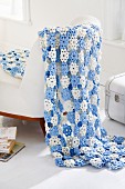 Blue and white blanket of crocheted flowers