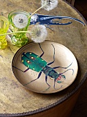 Plate decorated with beetle motif decoupage