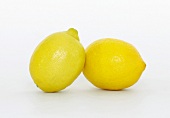 Close-up of two fresh whole lemons on white background