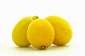 Close-up of three fresh whole lemons on white background