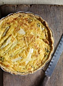 Close-up of asparagus quiche in baking dish with knife