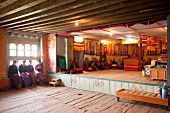 People praying at prayer hall of school, Ura valley, Bhutan