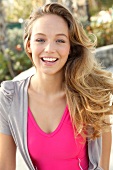 Portrait of beautiful blonde woman wearing pink and gray top, smiling