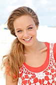 Portrait of pretty woman wearing orange-shirt and white fishnet top, smiling, close-up