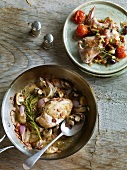 Chicken with white wine in pot and rabbit with olives on plate