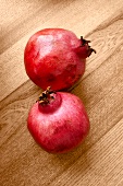 Close-up of two pomegranates on wooden plate