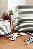 Stacks of plates and dishes with cutlery