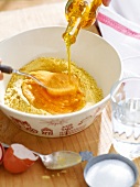 Close-up of oil being poured in pasta dough in bowl