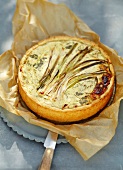 Cheese cake with herbs and green onions on brown packing paper