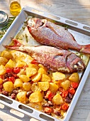 Close-up of sea bream with potatoes in baking dish
