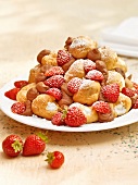Piles of Italian small puffs with strawberries on plate