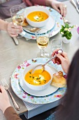 Two women having cream of carrot soup with rabbit made of pizza dough