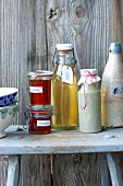 Bottles of dandelion honey and elderflower syrup on wooden table