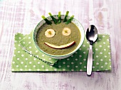 Bowl of green soup decorated for children