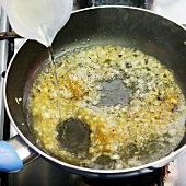Close-up of wine gravy being deglazed in pan