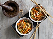 Stir fried chicken and vegetable in bowls, overhead view