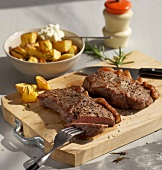 Potatoes steaks with rosemary on wooden board