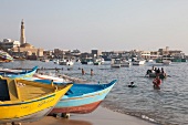 View of people enjoying and fishing boats moored at the Port of Alexandria, Egypt