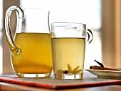 Herbal tea in glass jar and glass cup with handle