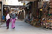 Rear view of two woman walking in Egypt tourist market, Aswan, Egypt