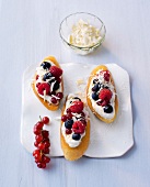Three crostinis with curd and berries on plate