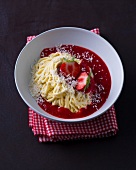 Spaghetti ice-cream with strawberry sauce in bowl