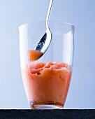 Blood orange sorbet with spoon in glass