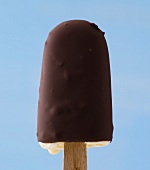 Close-up of ice lolly with chocolate coating against blue background