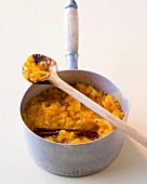 Mango chutney in sauce pan with wooden spoon on top