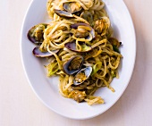 Rice pasta vongole with coriander pesto and mussels on plate