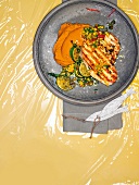 Grilled swordfish with sweet potatoes and mango salsa on plate