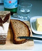 Close-up of brown bread with butter and knife on table