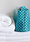 Close-up of blue toiletry bag with polka dots and folded towels