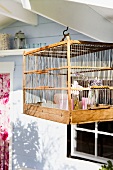 Wooden bird cage with flowers and candles