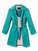 Close-up of turquoise trench coat over white dress on white background