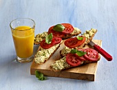 Whole grain rolls with tomato and basil cream on wooden board