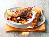 Salmon skewers with peppers in serving dish